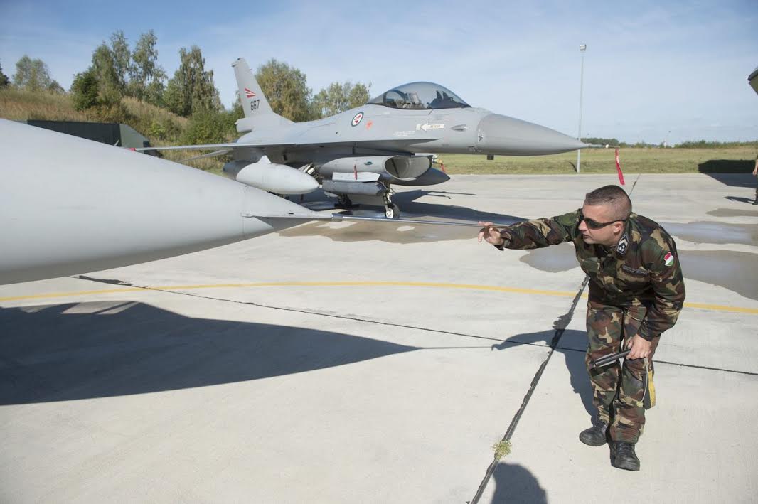 Balti báziskép: előtérben egy Gripen Pitot-csövét vizsgálja a földi szakember, háttérben egy norvég F-16-os