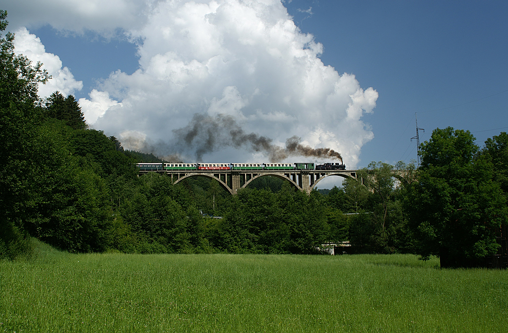 Az egész nyáron, illetve október végéig rendszeresen közlekedő nosztalgiavonat az impozáns Grub-viadukton. A vasbetonból épült, 276 méter hosszú híd a vasútvonal legnagyobb műtárgya. A 2006 júliusában készült felvételen a „fellegekben járó” 83-180-as gőzmozdony füstje remek kontrasztot alkot a mögötte levő bárányfelhővel<br>A képre kattintva fotógaléria nyílik<br>(fotó: Kiss Mihály)