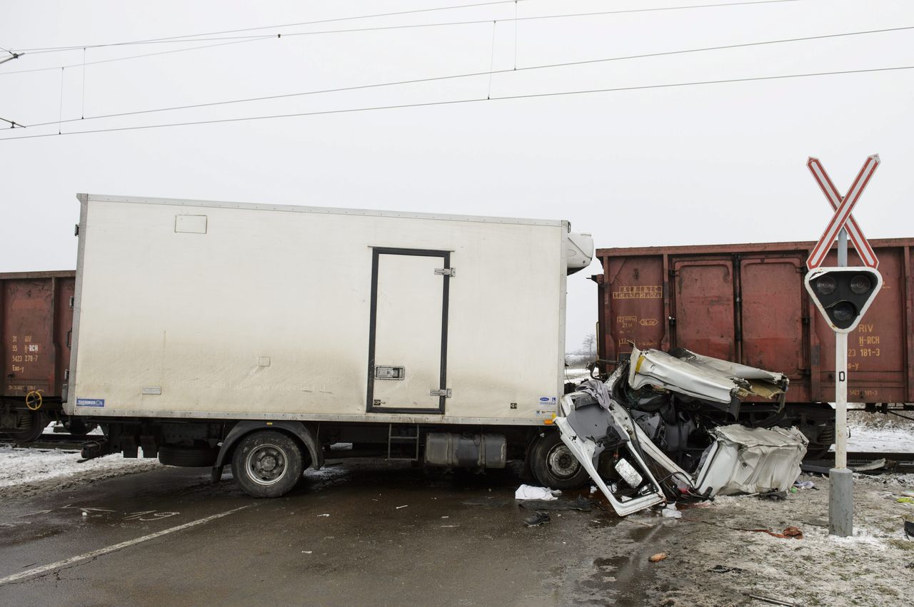 A tehervonatnak hajtó teherautóban utazó két személyt a tűzoltók vágták ki. A képre kattintva galéria nyílik.<br>(fotók: MTI/Komka Péter)