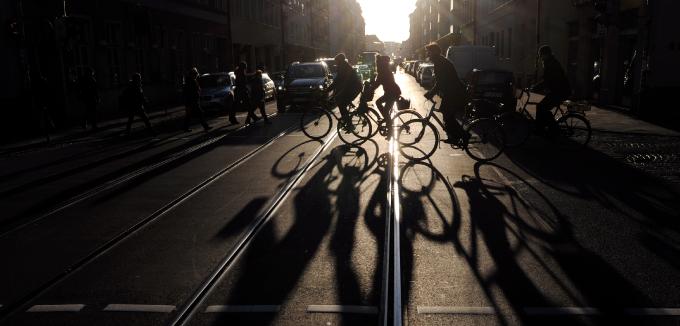 Ellenfényes utcai nyüzsgés Münchenben, kerékpárosokkal