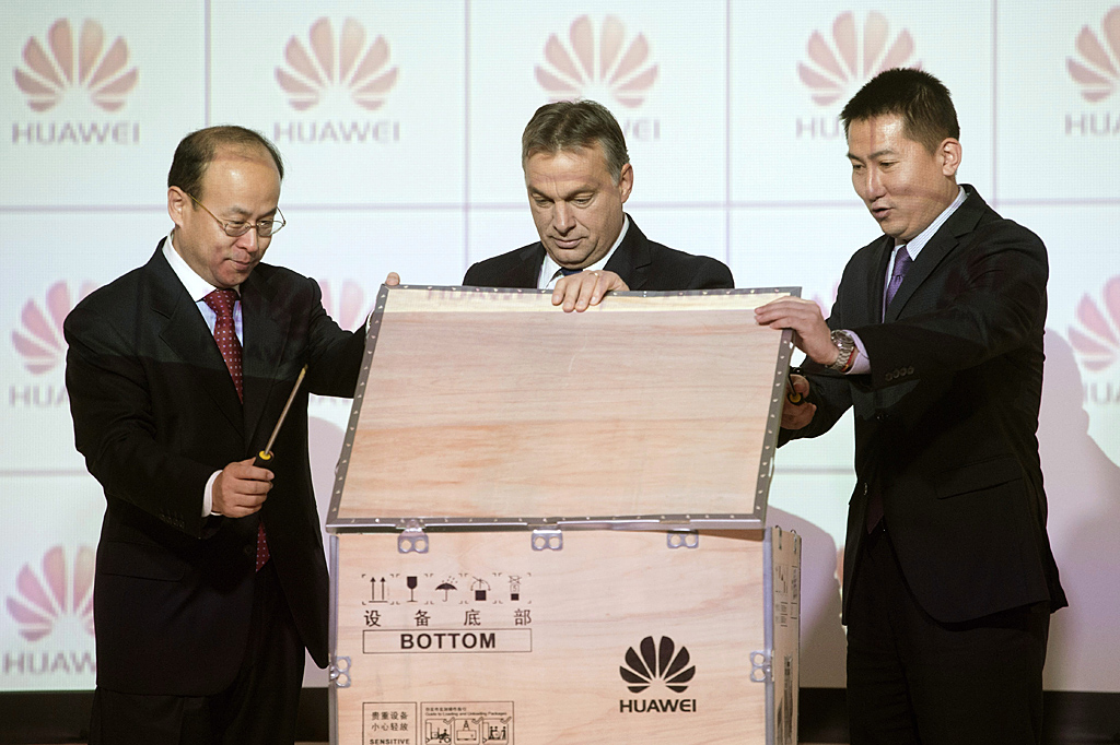 Hsziao Csien, a Kínai Népköztársaság nagykövete, Orbán Viktor miniszterelnök és Cso Csün, a Huawei kelet-közép-európai elnöke egy küldemény felbontásával nyitja meg a kínai cég logisztikai központját<br>(fotó: MTI/Koszticsák Szilárd)