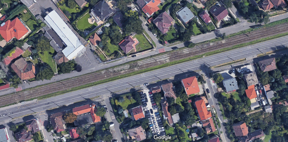 A Veres Péter út egy mértékadó szakasza. Minimális korrekcióval, a zöldsáv megszüntetésévelm középre kerülhetne a vasúti pályatest, melyet mindkét oldalán egy-egy egyirányú útpálya határolna (forrás: googlemaps)