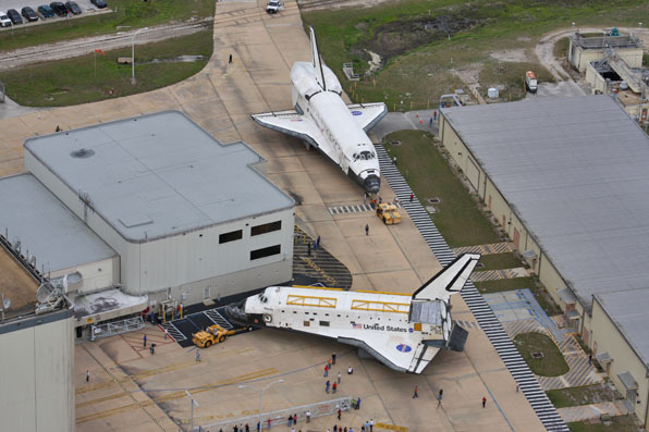 Az Atlantis és a Discovery néhány hete még együtt volt a Kennedy űrközpontban, a Discoveryn már látható a törzs hátsó részére felszerelt és az átrepüléshez szükséges burkolat <br>(fotók. space.com, NASA)