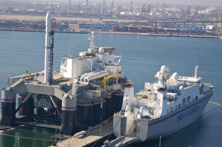 A kikötőben balra az olajplatformból épített kilövőpad, jobbra a kísérőhajó, az irányítóközponttal és a rakétát előkészítő részleggel (fotó: Sea Launch)