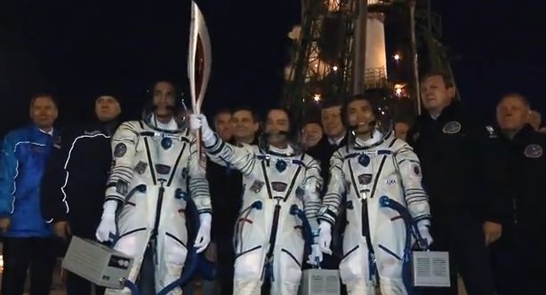 Bajkonurban a start előtt: balról az amerikai, jobbról a japán űrhajós, középen az orosz a lánggal