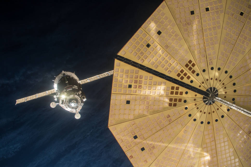 Az űrhajó visszahelyezkedik a kézi irányítású megközelítéshez, előtérben a Cygnus egyik napelemtáblája