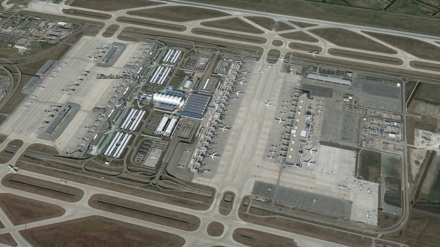 Tavalyi Google Earth fotó dél felől a reptérről: a jobboldali hosszú épület a szatellit, majd a gurulóutak, aztán a még hosszabb 2-es, majd még nyugatabbra az 1-es terminál