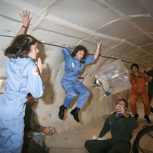 Christa McAuliff (középen) felkészülés közben, zéró-gravitációs repülés közben