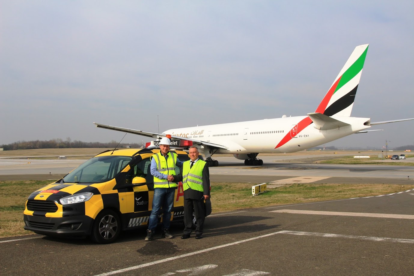 Stephan Schattney, a Budapest Airport Műszaki Központ igazgatója és Vas ferenc előtér felügyelőő, mögöttük az Emirates 777-ese gurul