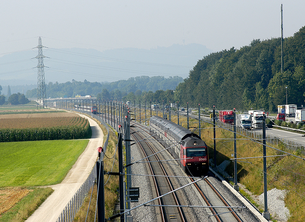 Két, emeletes IC-szerelvény találkozása Svájcban, a Mattstetten–Rothrist vonalon. Az új építésű vonalakat a környezeti terhelés mérséklése miatt gyakran autópályák mellé építik, így kialakul egy-egy „közlekedési folyosó”<br>(fotó: SBB)