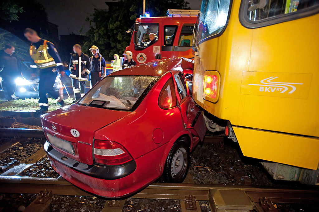 Az összeroncsolódott autó a villamos alatt<b>(fotó: Lakatos Péter, MTI)