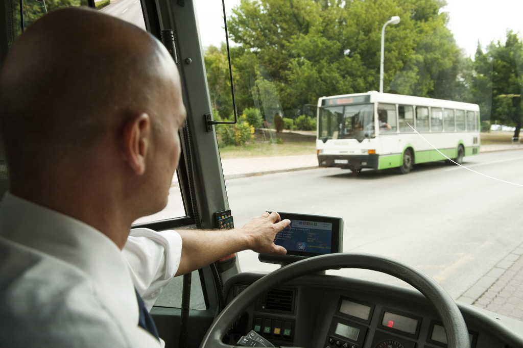 Egy buszsofőr kezeli a Vértes Volán új elektronikus forgalomirányítási és utastájékoztató-rendszerének egyik készülékét Tatabányán<br />(fotó: MTI / Koszticsák Szilárd)