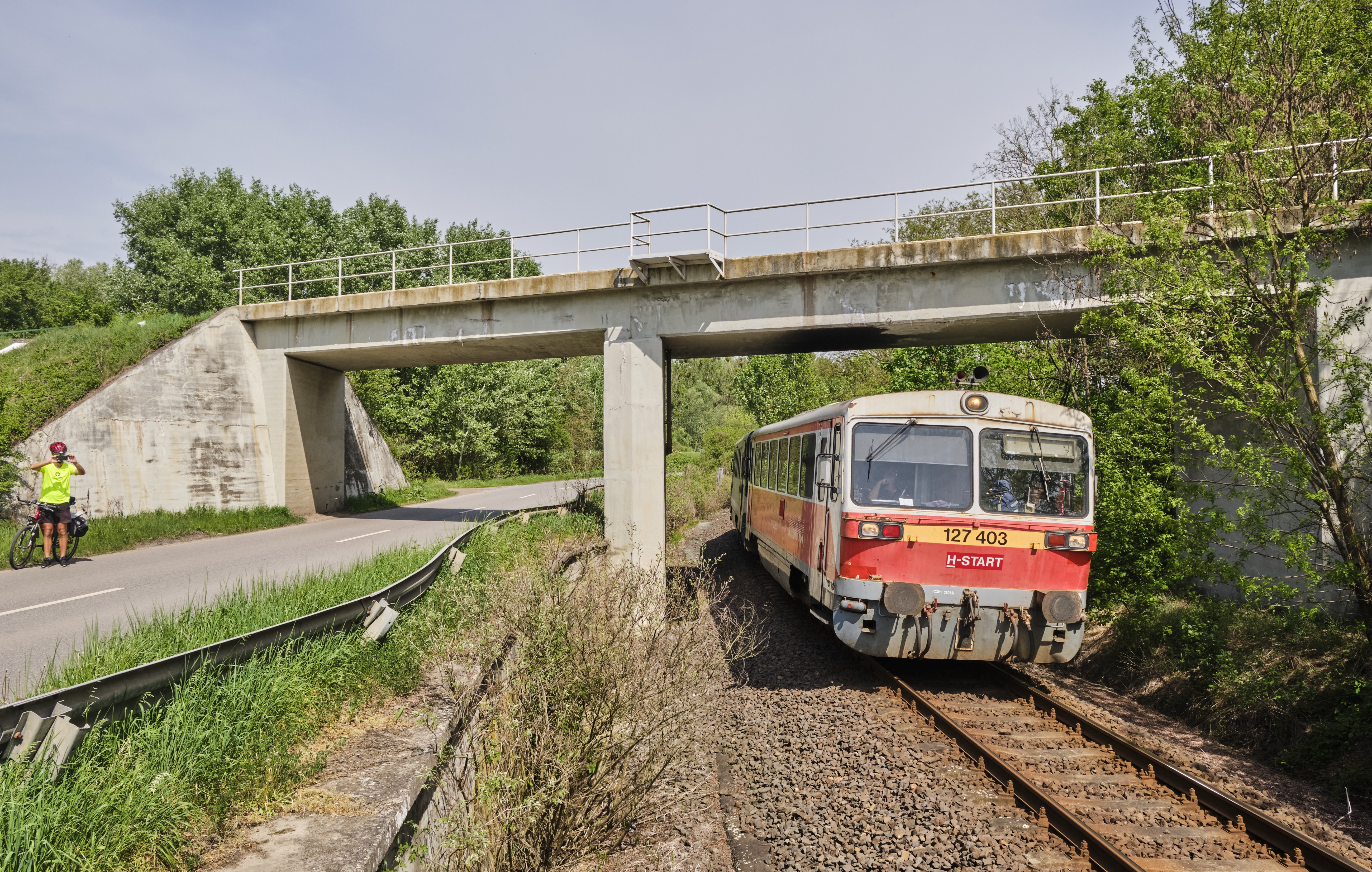 Kopó pompa. A 11 évet megért interpici vonatnem megszűnése, 2010 decembere óta a 400-as Bézék zömmel Szabolcs-Szatmár-Beregben, mellékvonali szolgálatban dolgoznak. Képünkön Mátészalkáról érkezik meg Záhonyba 2024. április 15-én a 403-as motor egy mellék kocsival – fölötte a csapi vonal ível át a Tisza-hídra vezető vasúti felüljárón (fotó: Vörös Attila)