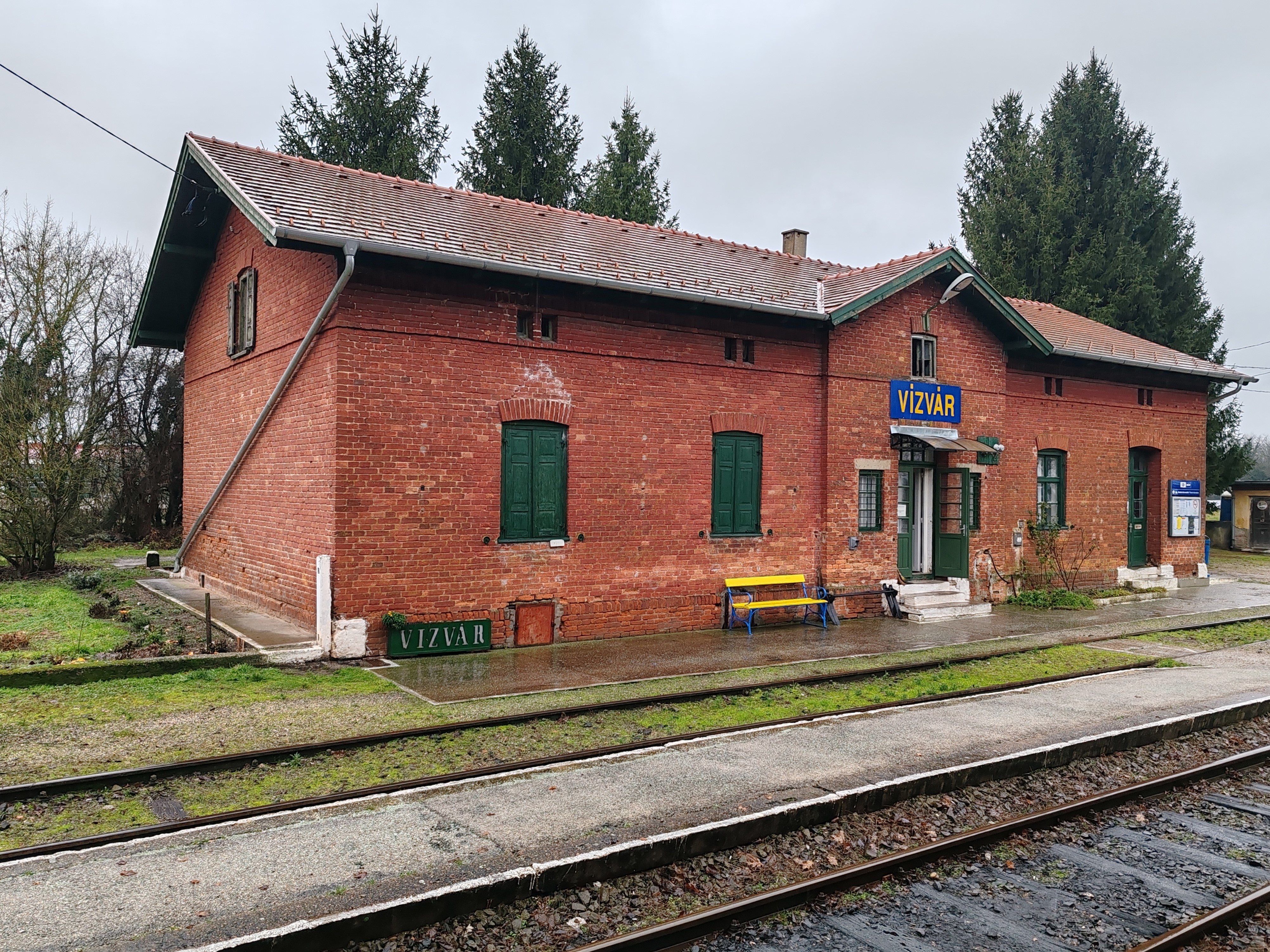 Vízvár 1868-ban felhúzott vöröstéglás felvételi épülete. 1868… Az év, amikor megalakult a Magyar Királyi Államvasutak, megszületett Horthy Miklós és Makszim Gorkij, elhunyt Szendrey Júlia, feltárták a cro-magnoni ember csontvázát és még két évig III. Napóleon volt a francia államfő, arról nem is beszélve, hogy rekord hosszúságú – mintegy tíz percen át tartó – teljes napfogyatkozás tartotta lázban Dél-Kelet Ázsia népét. De visszatérve Vízvárra, az állomáson fényjelzővel felszerelt kulcsazonosító berendezés üzemel. Vízvár és Berzence állomásközben állomástávolságú közlekedési rend van érvényben. Aki még nem fordult meg vonattal Szentlőrinc és Murakeresztúr között, javasoljuk, tegye meg, annak ellenére élmény, hogy a hosszú dezirózás azért egy kicsit megtöri a bumlizót, érzékei eltompulnak, lelkesedése enyhén hanyatlik. Zákány után, a nyár óta GYSEV kezelésű szakaszon fekvő Őrtilos a közeli, már a Murával egyesült Drávával kész gyöngyszem, ahol még teljes csapórudas mechanikus kezelésű sorompó is akad. Ekkor a Szentlőrincen összeszedett késés miatt még kétséges, hogy elérjük-e Nagykanizsán a 217-es Tópartot. A jegyvizsgálónak ez az első kanizsai útja, de megnyugtat, felhívja az ottani forgalmi szolgálattevőt, várják meg a Pannóniát, mert lesz átszálló. Aztán beszél a motorkocsi-vezetővel is, aki megértően bólogat, majd jön a hír, a menetrendben van annyi tartalék, hogy még időben odaérjünk. Hála! Ennek csak egy későbbi csatlakozás miatt lehetett jelentősége, mert a két órával későbbi Agram-Tópart az utolsó Dunaújvárosba induló, Z42 helyett már S42 vonatként közlekedő Flirt után ért volna Kelenföldre, és jóllehet, az irodában van egy matrac, azt most szívesen kihagytuk volna