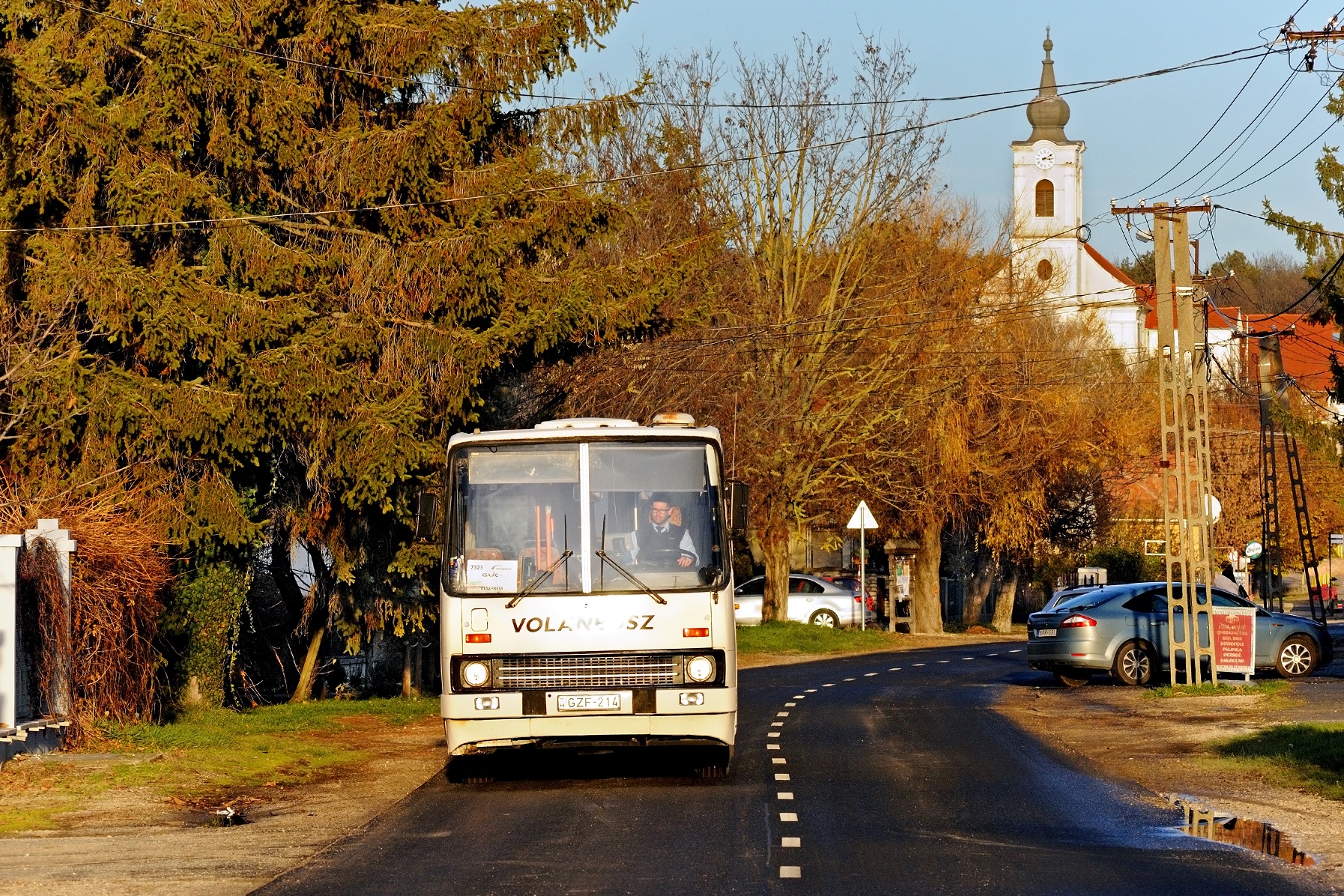 A lenyugvó napnak is van ereje. Az utolsó napsugarak még dobnak egy csókot az IDZ-426-ost pótló GZF-214-esre. A háttérben Balatonfőkajár református temploma magasodik